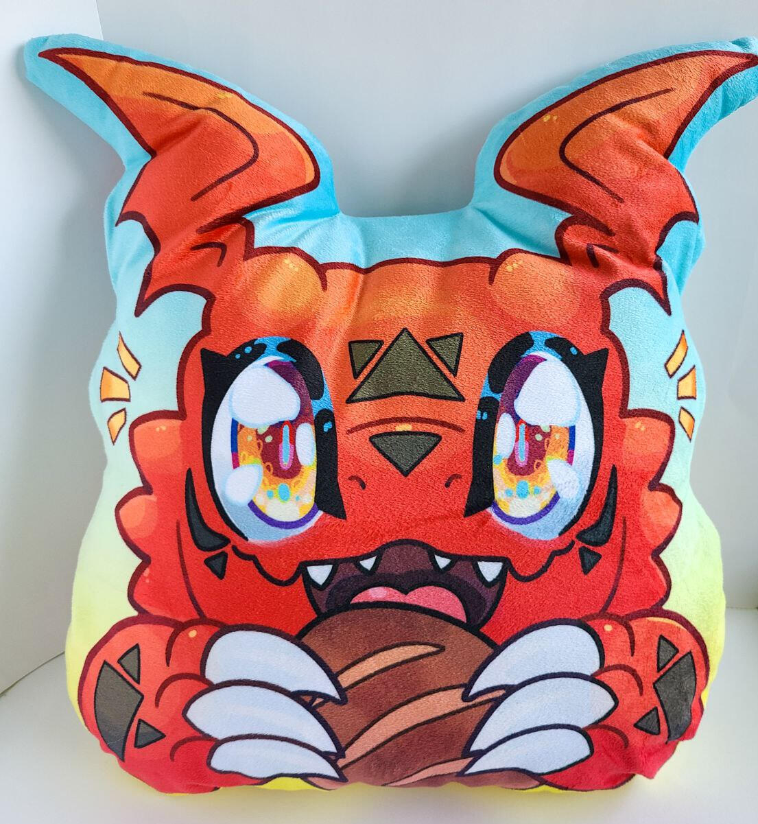 A pillow in the shape of a bright red dragon holding a bread bun. It is on a bright blue to yellow gradient background.