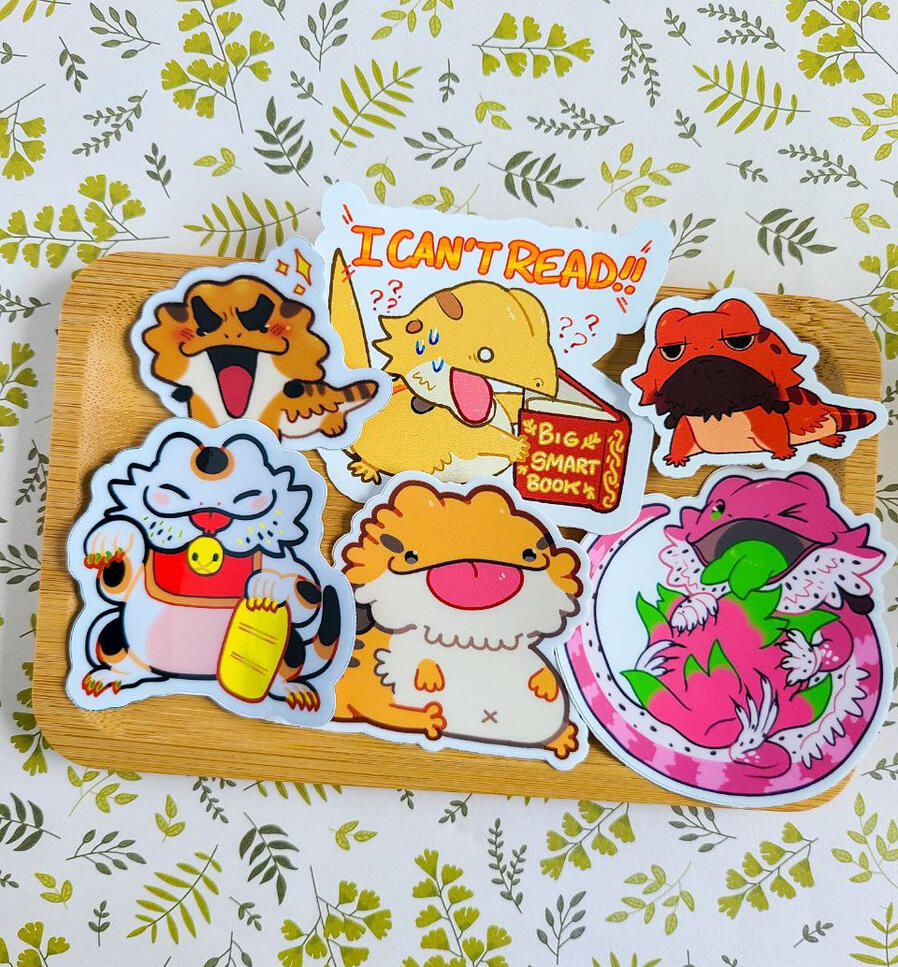 A tray of six colorful bearded dragon stickers.
